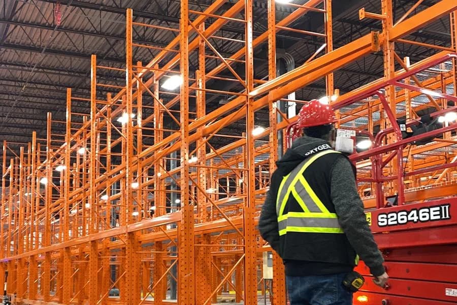 Technicien de 3E Racking Systems inspectant un palettier en entrepôt