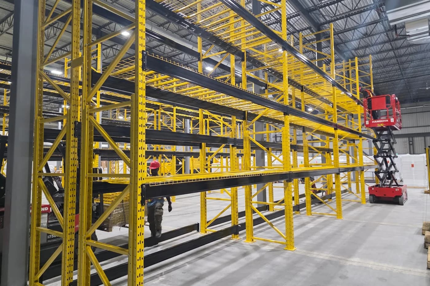 Installation de palettier par l'équipe de 3E Racking Systems avec nacelle élévatrice